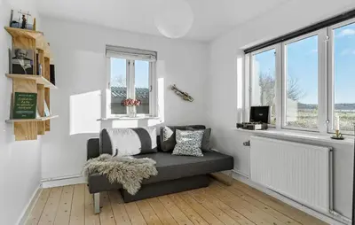 a living room with a couch and windows at 3 Bedroom Cozy Home In Nibe in Nibe