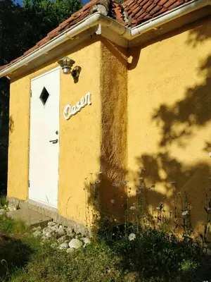 a building with a door with the word costachi on it at Charming Summer House From 1945 in Sønder Ydby