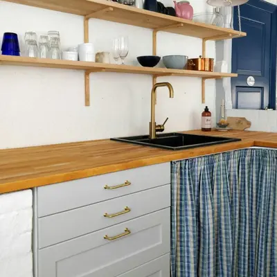 a kitchen with a sink and wooden counter top at Charming Summer House From 1945 in Sønder Ydby