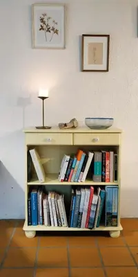 a book shelf filled with books next to a wall at Charming Summer House From 1945 in Sønder Ydby