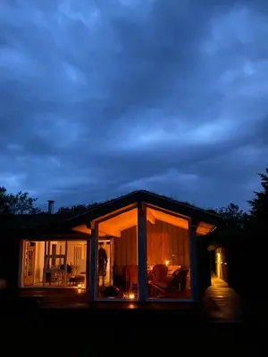 a house with large glass doors on the side of it at A Gem In The Woods Close To The North Sea in Rødhus