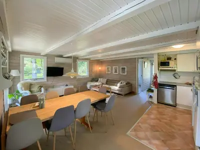 a living room with a large wooden table and chairs at Familievenligt Hus Nær Tranum Klitplantage in Pandrup