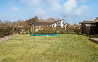a yard with a blue trampoline in the grass at Amazing Home In Lemvig in Lemvig