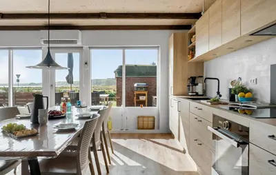 a kitchen with a large window and a table with chairs at Amazing Home In Lemvig in Lemvig