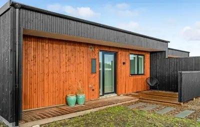 a wooden house with a black roof at Amazing Home In Thisted With Wifi in Thisted