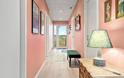 a hallway with pink walls and a table with a lamp at Amazing Home In Thisted With Wifi in Thisted