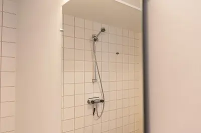 a shower with a shower head in a bathroom at Jetsmark Idrætscenter in Pandrup
