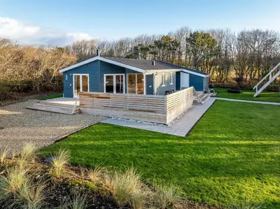 a blue tiny house with a large yard at Beautiful Holiday Home With A Lovely View Of The Fjord And The Sea in Vestervig
