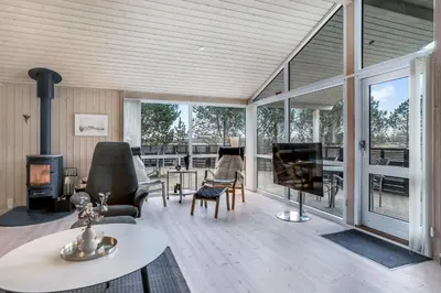 a living room with a fireplace and a large window at Lovely Holiday Home With Wilderness Bath And Space For 8 People in Pandrup