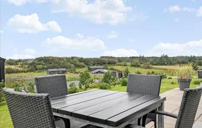 a wooden table and chairs on a patio at Amazing Home In Fjerritslev in Fjerritslev