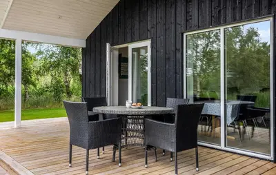a patio with a table and chairs on a deck at 2 Bedroom Amazing Home In Hurup Thy in Sønder Ydby