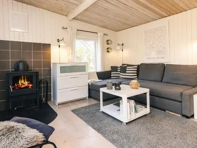 a living room with a couch and a fireplace at 6 person holiday home in Nibe in Nibe