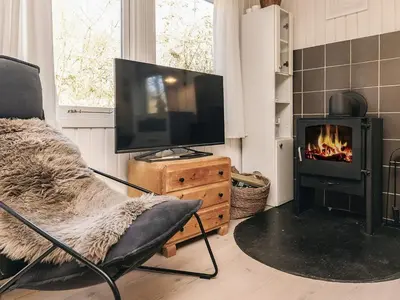 a living room with a television and a fireplace at 6 person holiday home in Nibe in Nibe