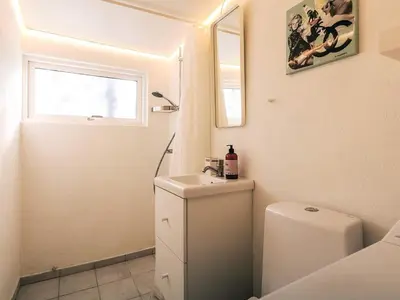 a bathroom with a sink and a toilet and a window at 6 person holiday home in Nibe in Nibe