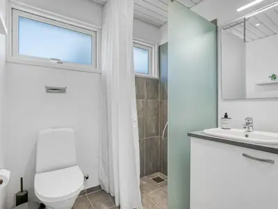 a white bathroom with a toilet and a sink at Holiday Home Elisenda - 2-2km from the sea by Interhome in Blokhus