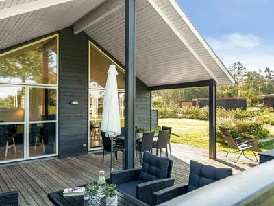 a patio with a table and chairs and a umbrella at Holiday Home Carlina - 700m to the fjord by Interhome in Løgsted