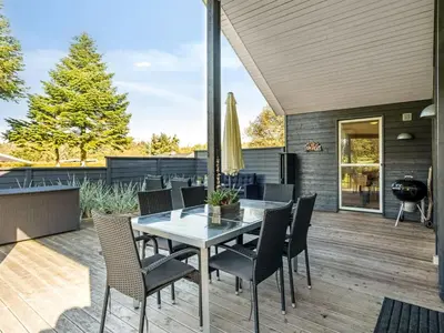 a patio with a table and chairs and a grill at Holiday Home Carlina - 700m to the fjord by Interhome in Løgsted