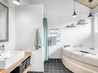 a white bathroom with a tub and a sink at Holiday Home Carlina - 700m to the fjord by Interhome in Løgsted