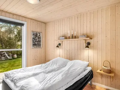 a bedroom with a bed in a room with a window at Holiday Home Carlina - 700m to the fjord by Interhome in Løgsted