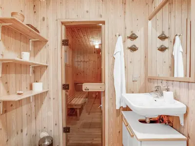 a bathroom with wooden walls and a sink and a tub at Holiday Home Cate - 900m from the sea by Interhome in Saltum