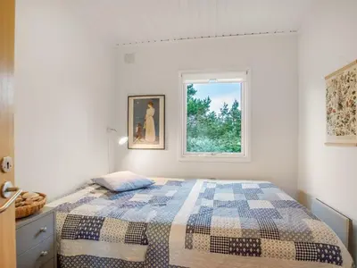 a bedroom with a bed and a window at Holiday Home Cate - 900m from the sea by Interhome in Saltum