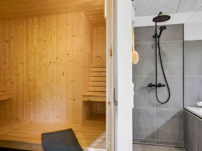 a bathroom with a walk in shower next to a staircase at Holiday Home Helga - 900m from the sea by Interhome in Blokhus