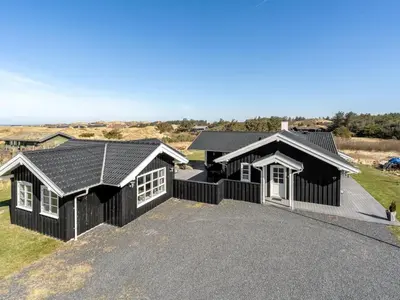 a house with a black roof and a driveway at Holiday Home Djuna - 550m from the sea by Interhome in Saltum