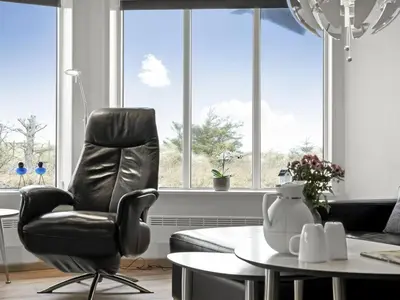 a living room with a chair and a table at Holiday Home Djuna - 550m from the sea by Interhome in Saltum