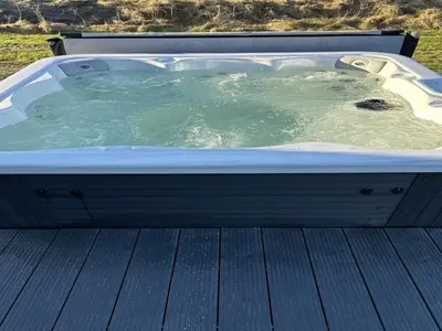 a hot tub sitting on top of a wooden deck at Holiday Home Djuna - 550m from the sea by Interhome in Saltum