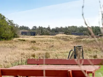 a red bench sitting in the middle of a field at Holiday Home Djuna - 550m from the sea by Interhome in Saltum