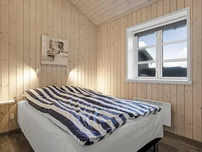 a bedroom with a bed and a window at Holiday Home Djuna - 550m from the sea by Interhome in Saltum
