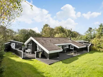 a modular house with a deck in a yard at Holiday Home Gonda - 2km from the sea by Interhome in Saltum