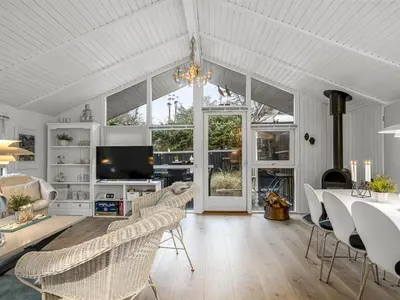 a living room with white furniture and a large window at Holiday Home Gonda - 2km from the sea by Interhome in Saltum