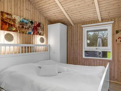 a bedroom with a white bed and a window at Holiday Home Gonda - 2km from the sea by Interhome in Saltum