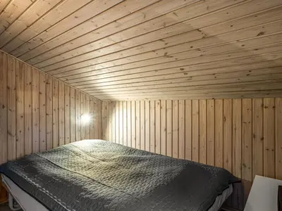 a bedroom with a bed in a wooden room at Holiday Home Gonda - 2km from the sea by Interhome in Saltum