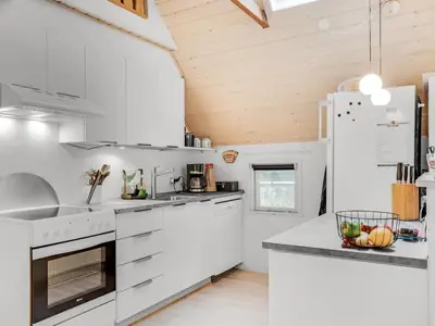 a kitchen with white appliances and a wooden ceiling at Holiday Home Adisl - 600m to the fjord by Interhome in Løgsted
