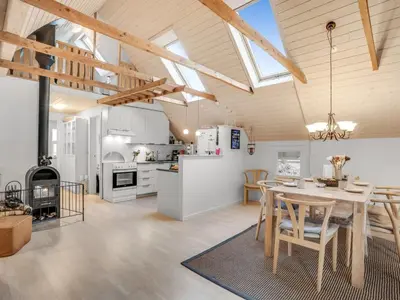 a kitchen and dining room with a table and chairs at Holiday Home Adisl - 600m to the fjord by Interhome in Løgsted