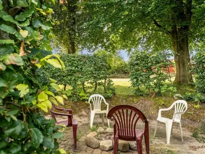 four chairs and a table in a garden at Holiday Home Jantje - 500m to the fjord by Interhome in Spottrup