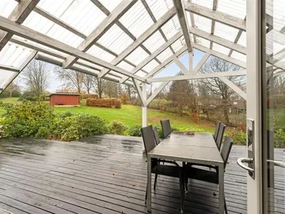 a patio with a table and chairs on a deck at Holiday Home Jantje - 500m to the fjord by Interhome in Spottrup