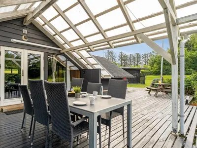 a patio with a table and chairs under a pergola at Holiday Home Jantje - 500m to the fjord by Interhome in Spottrup