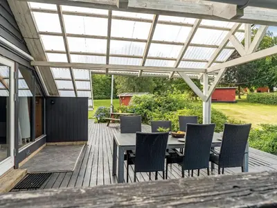 a patio with a table and chairs under a pergola at Holiday Home Jantje - 500m to the fjord by Interhome in Spottrup