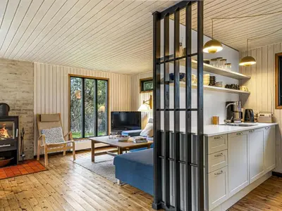 a living room with a kitchen and a living room with a couch at Holiday Home Star - 600m from the sea by Interhome in Løkken