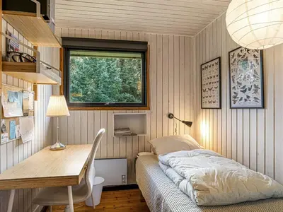 a bedroom with a bed and a desk and a window at Holiday Home Star - 600m from the sea by Interhome in Løkken