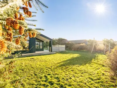 a house in a garden with the sun shining at Holiday Home Godja - 300m from the sea by Interhome in Torsted