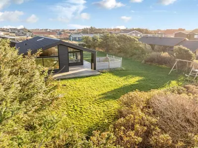 a small house on a hill with a green yard at Holiday Home Godja - 300m from the sea by Interhome in Torsted
