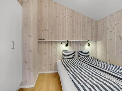 two beds in a room with wooden walls at Holiday Home Godja - 300m from the sea by Interhome in Torsted