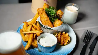 a plate of food with french fries and dipping sauce at Cityinn Hotel in Viborg