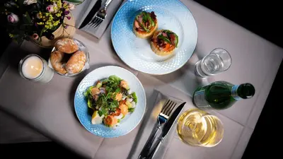 a table with three plates of food and a bottle of wine at Cityinn Hotel in Viborg