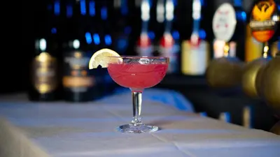 a red drink in a glass sitting on a bar at Cityinn Hotel in Viborg