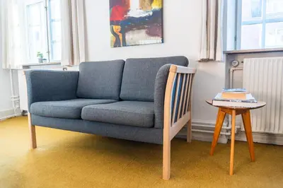 a blue couch in a living room with a table at Cityinn Hotel in Viborg